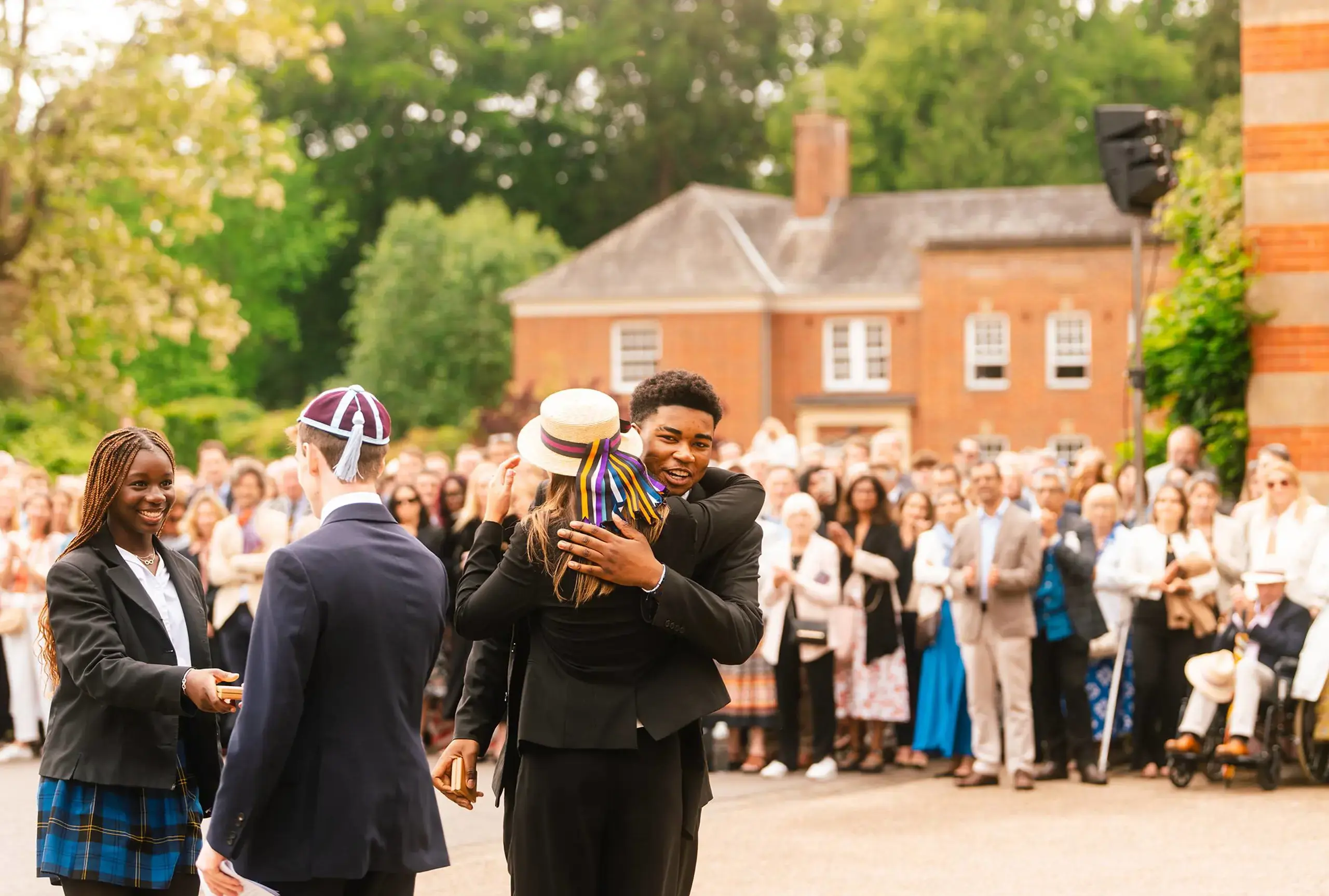 Students and teacher embracing during event